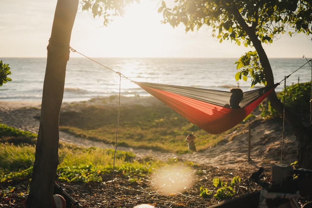 man on red and black hammock